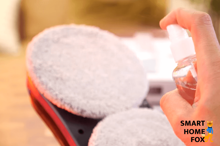 Die Wischpads des Fensterreinigungsroboters werden mit einem Reinigungsmitel eingesprüht